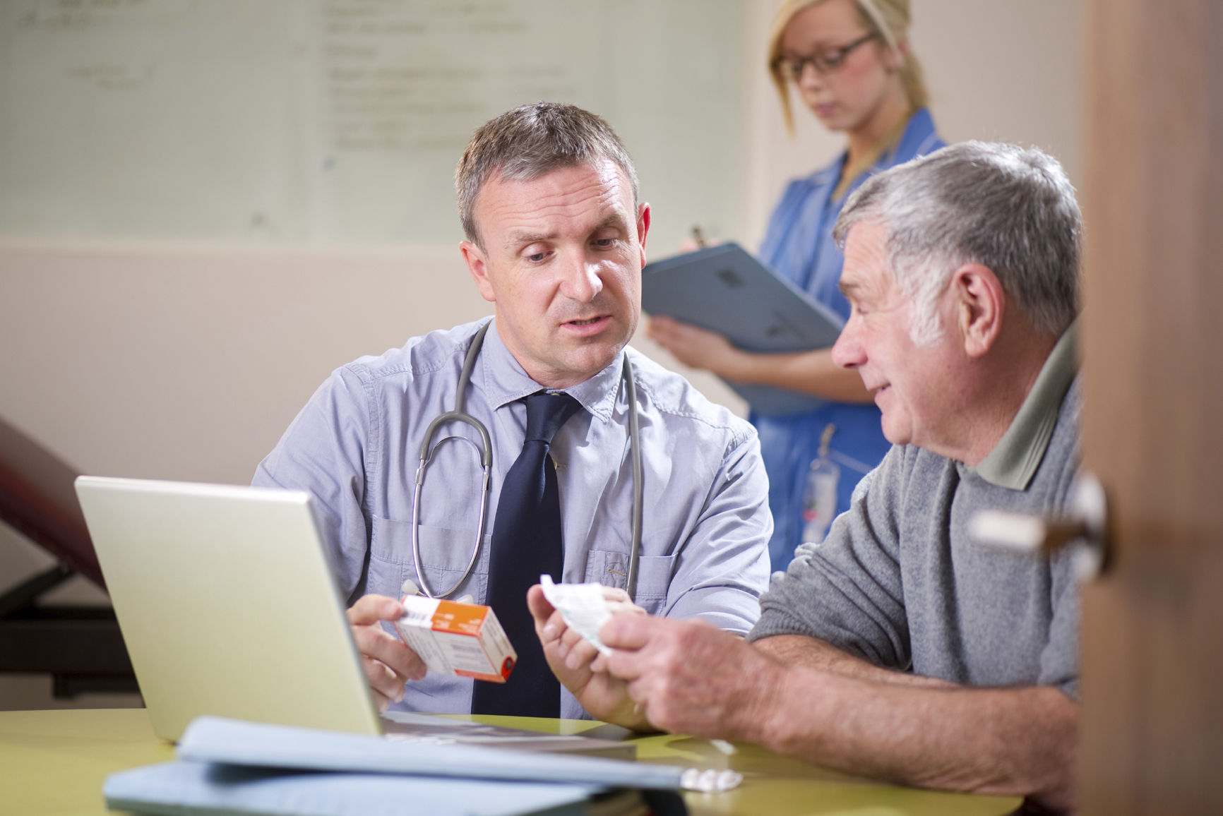 Image of a doctor in front of a computer talking to a patient