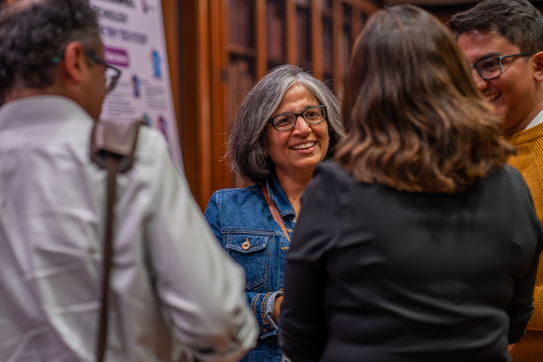 A group of smiling people talking to one another at a living kidney donation awareness raising event
