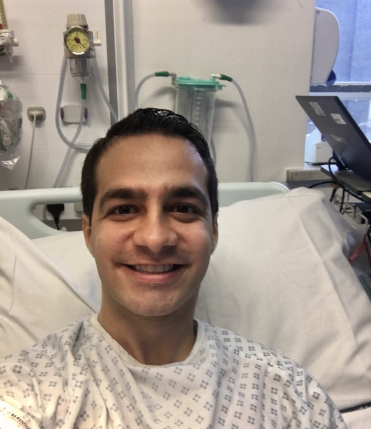 Living kidney donor Ali in a hospital bed smiling at the camera