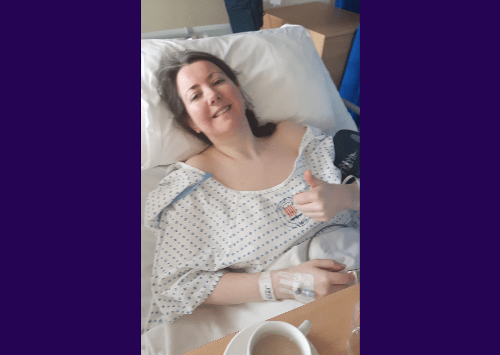 Living kidney donor Lesley laying on a hospital bed in a hospital gown. Her head is resting on the pillow and she is giving a light thumbs up for the camera.